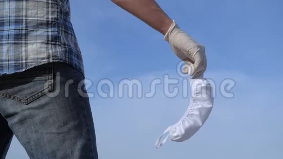 戴着医用手套的男性志愿者手里拿着医用口罩视频的预览图