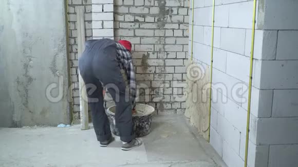 工作人员穿戴红帽抹灰加气混凝土砌块墙视频的预览图