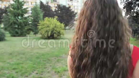 迷人的年轻女性在公园外享受她的时光背景是日落视频的预览图
