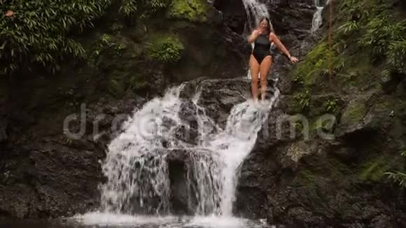 女人在瀑布下面的水池里跳视频的预览图