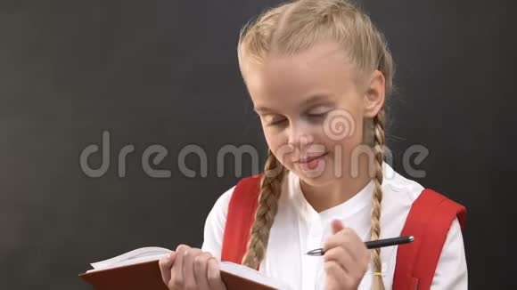 有创意的小女孩写作业在笔记本学校教育家庭工作视频的预览图