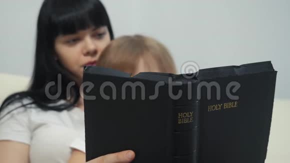 妈妈女儿读圣经宗教观念生活方式圣书信徒小女儿和妈妈读圣经视频的预览图