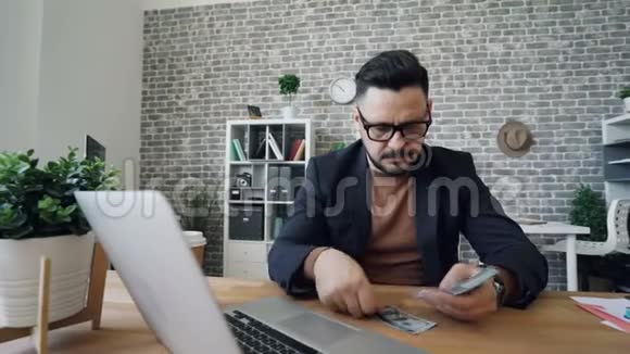 有钱的企业家在工作时微笑着坐在办公桌旁视频的预览图