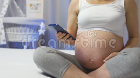 年轻女性使用怀孕追踪应用程序视频的预览图