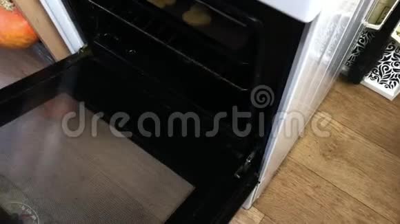 一个女人从烤箱里拿出一张烤盘和准备好的姜饼从上方拍摄视频的预览图