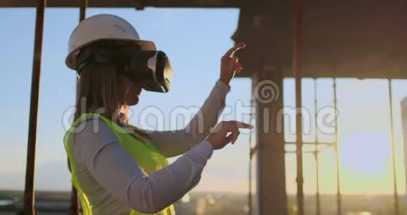 女专家工程师戴着VR眼镜和头盔检查摩天大楼的建设进度动动手视频的预览图
