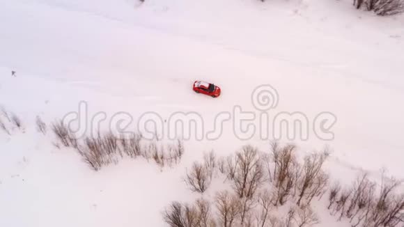 橙色的车骑在冬天的雪道上俯视着视频的预览图