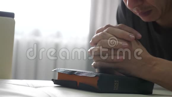 人们在睡前用圣经在室内祈祷生活方式宗教概念晚祷人类深色手圣经祈祷视频的预览图