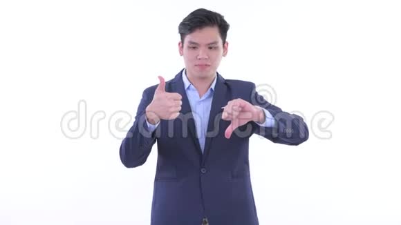 困惑的年轻亚洲商人在竖起大拇指和竖起大拇指之间做出选择视频的预览图
