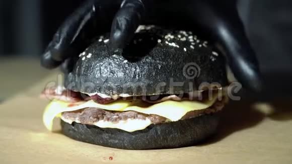 厨师的双手合拢用奶酪熏肉和樱桃酱煮一个黑色汉堡视频的预览图