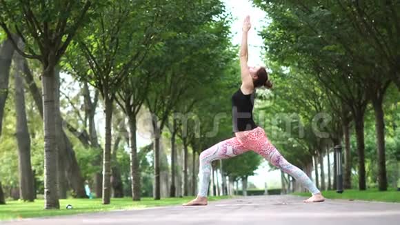 年轻女孩在公园小巷慢动作做瑜伽视频的预览图