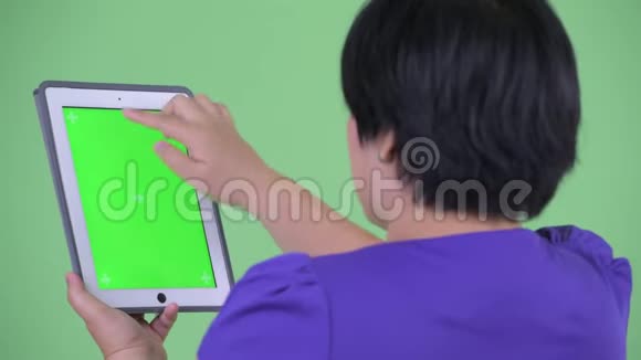 使用数码平板电脑拍摄快乐年轻超重的亚洲女性的近距离后视镜视频的预览图