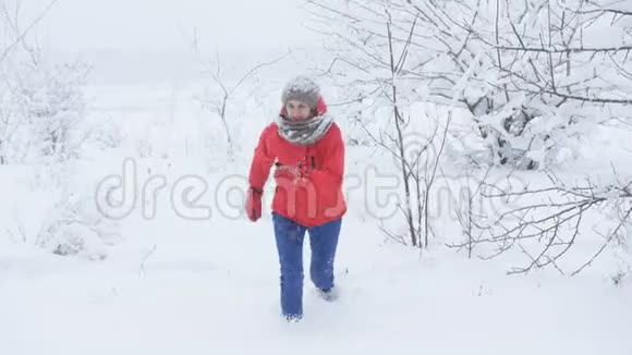 一个女人在雪地里的森林里奔跑穿过雪地视频的预览图