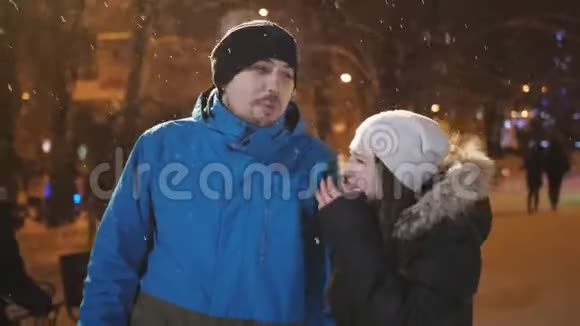 晚上在圣诞市场上有一对快乐迷人的夫妇漂亮的bokeh灯光背景视频的预览图