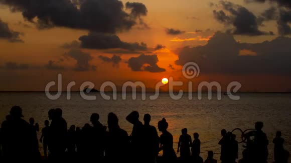 日落时在海滩上的派对无法辨认的人欣赏海上的日落视频的预览图
