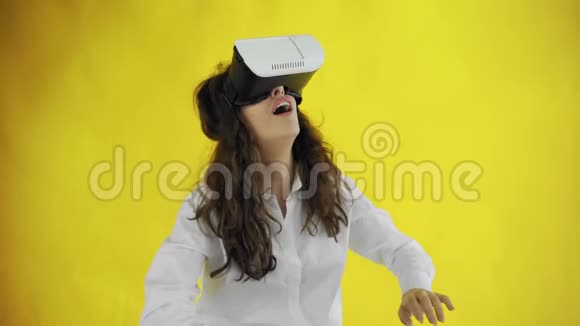 快乐的年轻女子与虚拟现实耳机或3D眼镜黄色背景在工作室视频的预览图