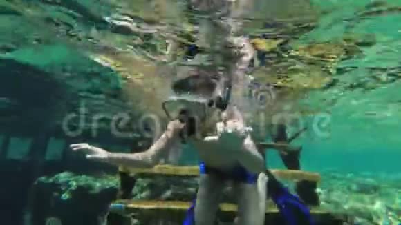 带口罩和管子的小男孩第一次在珊瑚礁附近的红海浮潜视频的预览图