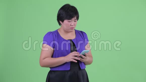 快乐的年轻超重的亚洲女人用电话打出租车视频的预览图