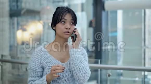 中锋悲伤的亚洲女性站在电话里交谈视频的预览图