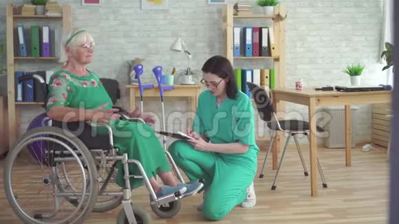 医生检查一位坐轮椅的老年妇女的健康状况视频的预览图