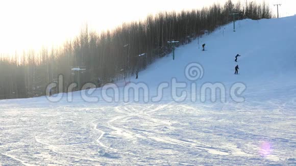 滑雪者和滑雪者乘坐滑雪场在雪山冬季背景风景视频的预览图