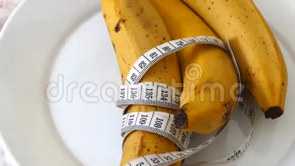 香蕉和健康减肥香蕉和饮食在白色背景上用卷尺测量视频的预览图