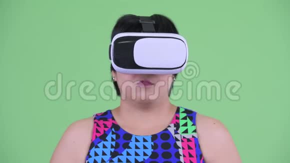使用虚拟现实耳机的快乐年轻超重亚洲女人的脸视频的预览图