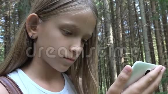 儿童在户外野营玩平板电脑儿童使用智能手机森林中迷路的女孩视频的预览图