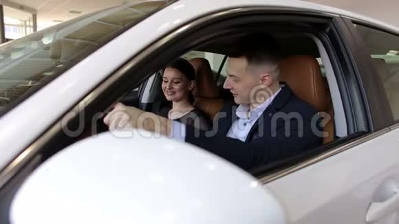 快乐的年轻夫妇在现代车展上买了一辆车特写镜头视频的预览图