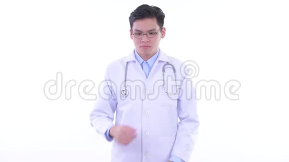 一位年轻的亚洲男医生在思考低头看着视频的预览图