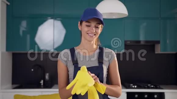 有魅力的年轻女性从清洁服务戴橡胶手套准备清洁厨房视频的预览图
