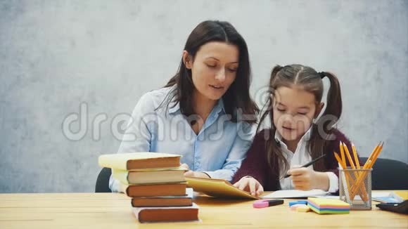 年轻的妈妈帮孩子写一堂课或者让女儿和妈妈都学会写有一个小女孩视频的预览图