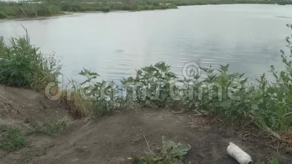 用两根钓鱼竿观赏天然池塘男人爱好和休闲视频的预览图