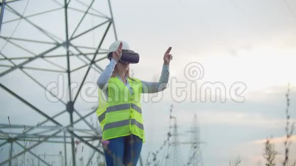 中期计划女性能源工程师在虚拟现实眼镜和白色头盔背景下的高压电力视频的预览图
