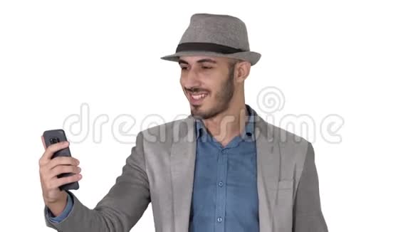有魅力的男人穿着休闲服装帽子时髦的风格记录vlog或在白色背景下打视频电话视频的预览图