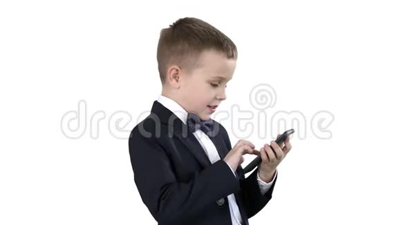 穿着优雅西装在白色背景上玩手机的小男孩视频的预览图