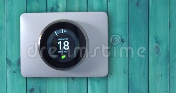 4k智能温控器一个人在绿色的木墙上设置温度视频的预览图