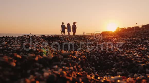 日落时分一家人带着孩子沿着冲浪线慢跑到海边视频的预览图