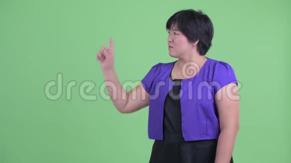 快乐的年轻超重的亚洲女人摸着东西看上去很惊讶视频的预览图