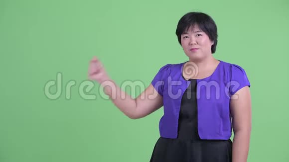 快乐的年轻超重的亚洲女人拍着手指看上去很惊讶视频的预览图
