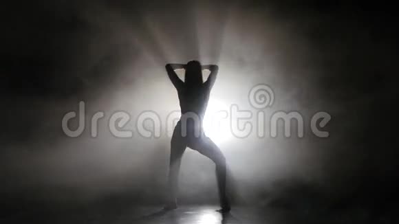 在烟雾弥漫的工作室里跳舞的剪影腿女孩视频的预览图