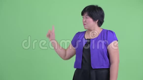 快乐的年轻超重的亚洲女人摸着东西看上去很惊讶视频的预览图