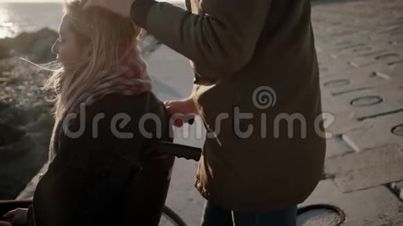 在海上男人正在抚摸着坐轮椅的心爱女人的头视频的预览图