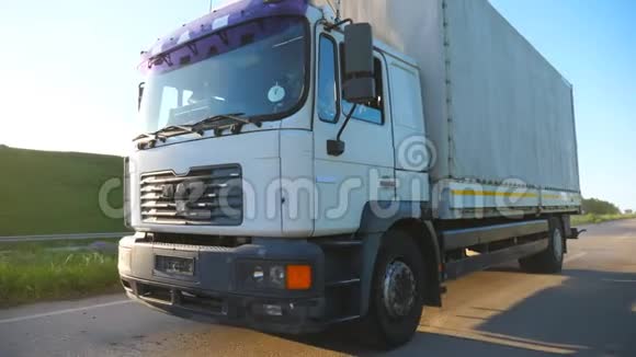 摄像机跟随卡车与货物拖车在公路上行驶和运输货物卡车在农村超速行驶视频的预览图