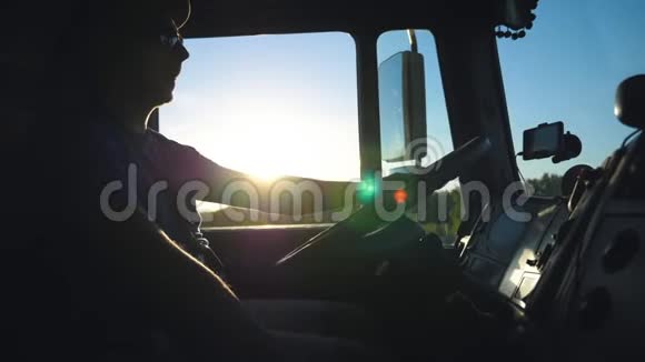 卡车司机晚上开车穿过乡村的剪影戴墨镜的人控制着卡车视频的预览图