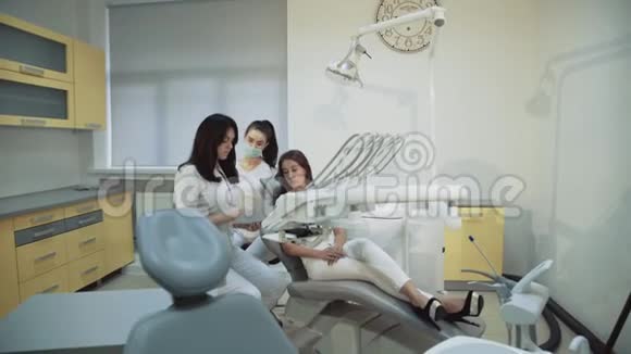 漂亮的女孩在牙科椅上咨询牙医使用x射线图像4K视频的预览图