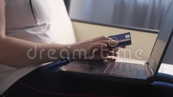 女孩用笔记本电脑数字平板电脑制作网上销售购物概念黑发女人躺在沙发上看生活用品店视频的预览图