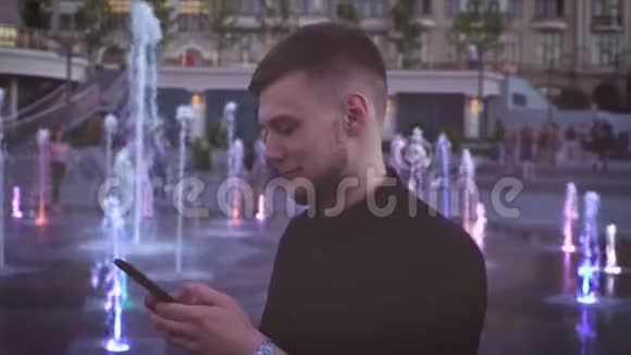 年轻的千禧一代使用智能手机在夏季晚间科技的繁华城市中的概念画像视频的预览图