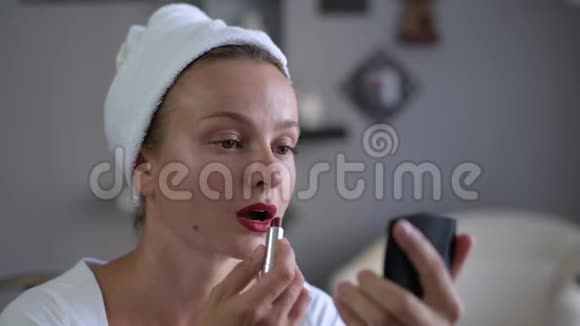 化妆女人嘴唇上涂着红色口红视频的预览图