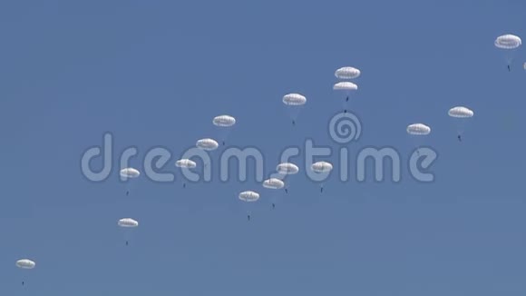 一支由军人组成的伞兵分队从天空降落到地面对抗蓝天视频的预览图